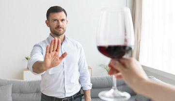 Мужчина отказывается от протянутого бокала